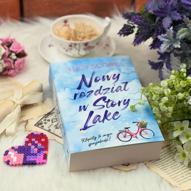 Lucy Score znowu to zrobiła. Napisała powieść, która rozczula, bawi i wciąga od pierwszej strony. „Nowy rozdział w Story Lake” to książka, po którą sięgnęłam z ciekawością, ale nie spodziewałam się, że zostawi mnie z uśmiechem na twarzy i autentycznym wzruszeniem. Autorka po raz kolejny udowadnia, że nikt nie pisze o małomiasteczkowych romansach tak dobrze, jak ona. Dosłownie nikt.

[…]

Uwielbiam styl Lucy Score – lekki, pełen humoru i emocji, z postaciami, które chciałoby się znać osobiście. Każdą jej książkę dosłownie pochłaniam, ale „Nowy rozdział w Story Lake” wskoczył u mnie na podium (zaraz obok serii Knockemout).

Hazel to cudowna postać – chaotyczna, gadatliwa, zadziorna, ale ciepła i dobra. Cam to jej kompletne przeciwieństwo – wycofany, nieco zblazowany, ale lojalny i skrycie troskliwy. Ich dialogi są świetne – pełne przekomarzania, zabawne, czasem bardzo szczere. W tej książce flirt gra pierwsze skrzypce i robi to genialnie. Dzięki temu całość jest urocza, ale nie przesłodzona.

Ogromnym plusem jest też samo Story Lake – miejsce, w którym roi się od barwnych postaci. To wszystko sprawia, że klimat powieści jest niesamowicie serialowy i przytulny. Zakochałam się w tym miasteczku. Podobało mi się, że relacja Hazel i Cama nie była typowa. Nie ma tu wielkich dramatów, tylko małe kroki, rozmowy, nieporozumienia i powolne budowanie zaufania. Było zabawnie, było uroczo, a końcówka… ach! Tak właśnie miało być. 

„Nowy rozdział w Story Lake” to idealna książka na poprawę humoru. Ciepła, pełna humoru, z cudownie wykreowaną społecznością i relacją, która rozwija się powoli, ale z ogromnym wdziękiem. Lucy Score po raz kolejny udowodniła, że zna się na rzeczy – i to jak! Jeśli szukasz książki o nowym początku, z mnóstwem emocji i postaciami, które chcesz zaprosić na kawę, to trafiłaś idealnie.

A mapka miasteczka? Cudo. Chcę tam zamieszkać.

—
Pełną recenzję znajdziesz na moim blogu — https://miye.eu 💜 [współpraca recenzencka] #mustread #takczytam #romans #bookstagram #bookstagrampl